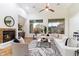 Bright living room featuring a fireplace, ceiling fan, and large windows showcasing the outdoor scenery at 37080 N 109Th Way, Scottsdale, AZ 85262