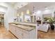 View of kitchen and living room featuring an granite counter bar, ceiling fan, and fireplace at 37080 N 109Th Way, Scottsdale, AZ 85262