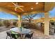 Outdoor kitchen and dining area under a covered patio, complete with a built-in grill and scenic views at 37080 N 109Th Way, Scottsdale, AZ 85262