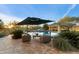 Inviting backyard oasis with a sparkling pool, waterfall feature, covered pavilion, and ample seating at 37080 N 109Th Way, Scottsdale, AZ 85262