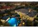 Aerial view of a private pool and spa with a covered bar area and fire pit at dusk at 37080 N 109Th Way, Scottsdale, AZ 85262