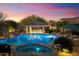 A luxurious pool at twilight with a swim-up bar, spa, and lush landscaping at 37080 N 109Th Way, Scottsdale, AZ 85262