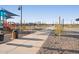 A long view of the concrete pathway bisecting the community park, with views of the playground and sports courts at 37093 W La Paz St, Maricopa, AZ 85138