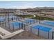 An elevated view of the neighborhood pickleball courts, which are fenced and include shaded benches at 37093 W La Paz St, Maricopa, AZ 85138