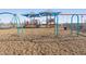 A brightly colored play structure with swings and sunshades is situated on soft mulch in the neighborhood park at 37093 W La Paz St, Maricopa, AZ 85138