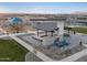 An aerial view of the park seating area, which includes a fireplace, grill, and covered area with chairs at 37093 W La Paz St, Maricopa, AZ 85138