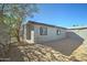 Backyard featuring a detached gray building, a metal fence and dirt landscaping at 3714 E Polk St, Phoenix, AZ 85008