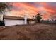 Spacious backyard with covered patio and red brick columns, ideal for entertaining under a vibrant sunset sky at 4052 W Eva St, Phoenix, AZ 85051