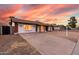 Single-story home boasting a well-lit entrance and a wide driveway, enhanced by desert landscaping at 4052 W Eva St, Phoenix, AZ 85051