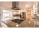 A kitchen with stainless appliances, white cabinets, and a range hood above the stone countertop at 4052 W Eva St, Phoenix, AZ 85051