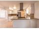 This kitchen features white cabinetry, stainless appliances, a range hood, and a stone countertop at 4052 W Eva St, Phoenix, AZ 85051