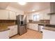 This updated kitchen has stainless steel appliances, white cabinets and contrasting backsplash at 4052 W Eva St, Phoenix, AZ 85051