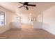 Bright open-plan living space featuring a ceiling fan, neutral tile flooring, and ample natural light at 4052 W Eva St, Phoenix, AZ 85051