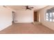 Bright living room with neutral tile flooring, white walls, ceiling fan, and access to adjacent spaces at 4052 W Eva St, Phoenix, AZ 85051