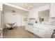 Bright open kitchen with white cabinets, marble countertops, a farmhouse sink, and modern gold fixtures at 4307 E Turney Ave, Phoenix, AZ 85018