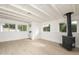 Living room featuring a brick accent wall, white wood beam ceilings, vinyl floors, and backyard access at 4307 E Turney Ave, Phoenix, AZ 85018