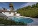 Backyard pool surrounded by white concrete, lush greenery, and a clear blue sky at 4307 E Turney Ave, Phoenix, AZ 85018