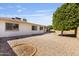 Expansive backyard with low-maintenance desert landscaping, mature trees, and a glimpse of the home's exterior at 4662 E Escondido Ave, Mesa, AZ 85206