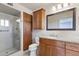 Updated bathroom with wood cabinets, a granite countertop, and a glass-enclosed shower at 4662 E Escondido Ave, Mesa, AZ 85206