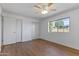 Bright bedroom with a ceiling fan, a window, and closet doors at 4662 E Escondido Ave, Mesa, AZ 85206