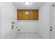 A bright laundry room with wood cabinets, tile floors, and a fresh, clean look, ready for any homeowner's needs at 4662 E Escondido Ave, Mesa, AZ 85206