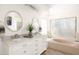 Light-filled bathroom showcasing a double vanity, soaking tub, and ample natural light at 4702 E Monte Cristo Ave, Phoenix, AZ 85032