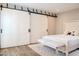 Bedroom with sliding barn doors, neutral colors, and an elegant white bed frame at 5100 N Miller Rd # 24, Scottsdale, AZ 85250