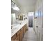 Bathroom featuring a double sink vanity and access to shower at 5259 W Village Dr, Glendale, AZ 85308