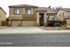 Charming two-story home featuring a three-car garage, tile roof, and landscaped front yard at 5259 W Village Dr, Glendale, AZ 85308