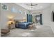 Bright main bedroom features a ceiling fan, multiple windows, and a sliding glass door to the outdoor patio at 56 S Prairie Rd, Gilbert, AZ 85296