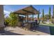 Outdoor kitchen with a built-in grill, bar seating, and a view of the pool at 56 S Prairie Rd, Gilbert, AZ 85296