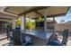 Outdoor kitchen featuring stone accents, a built-in grill, bar seating, and overhead lighting at 56 S Prairie Rd, Gilbert, AZ 85296