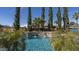 Beautiful pool area featuring a stacked stone water feature and lush landscaping at 56 S Prairie Rd, Gilbert, AZ 85296