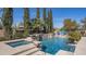 Gorgeous pool and spa with a stone waterfall feature, surrounded by lush landscaping at 56 S Prairie Rd, Gilbert, AZ 85296