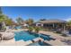 Backyard pool with a water feature, play structure, and covered patio, perfect for relaxing and entertaining at 56 S Prairie Rd, Gilbert, AZ 85296