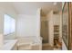 Spacious, all-white bathroom with tub, walk-in shower, and built in storage shelves at 5735 E Mcdowell Rd # 447, Mesa, AZ 85215