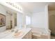 Bright bathroom features a large mirror, pink sink, and a tub with jets at 5735 E Mcdowell Rd # 447, Mesa, AZ 85215