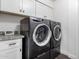 Convenient laundry room featuring a modern washer and dryer with storage cabinets above at 6707 E Aire Libre Ln, Scottsdale, AZ 85254