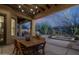 Covered patio with rustic chandelier, wood table, and seating with backyard desert views at 6993 E Soaring Eagle Way, Scottsdale, AZ 85266