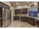 Stylish kitchen featuring stainless steel appliances, dark cabinetry, and granite countertops at 6993 E Soaring Eagle Way, Scottsdale, AZ 85266