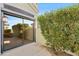 Patio and sliding glass doors in backyard with manicured hedge in a private outdoor space at 8100 E Camelback Rd # 43, Scottsdale, AZ 85251