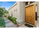 Inviting entryway with a wooden door, tile walkway and desert plants at 8100 E Camelback Rd # 43, Scottsdale, AZ 85251