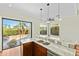 Well-lit kitchen with granite counters and outdoor view from sliding glass doors at 8100 E Camelback Rd # 43, Scottsdale, AZ 85251