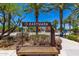 A decorative sign for the community entrance surrounded by palm trees, cacti, and other desert landscaping at 9303 E Static Ave, Mesa, AZ 85212