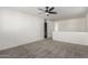 Cozy loft area with ceiling fan, neutral carpet, and view into the laundry room at 9303 E Static Ave, Mesa, AZ 85212