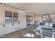 Covered back porch with access to an enclosed sunroom, featuring outdoor seating and storage at 9817 W Loma Blanca Dr, Sun City, AZ 85351