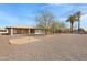 Backyard of home with low-maintenance landscaping, mature trees and community features at 9817 W Loma Blanca Dr, Sun City, AZ 85351