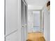 Hallway with a wood floor, closet with louvered doors, and a doorway leading to another room at 9817 W Loma Blanca Dr, Sun City, AZ 85351