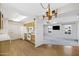 Open concept view of the kitchen, with wood cabinets and white appliances and view to living room at 9817 W Loma Blanca Dr, Sun City, AZ 85351