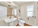 A clean bathroom features a pedestal sink, toilet, and tiled shower at 9834 W Evergreen Dr, Sun City, AZ 85373